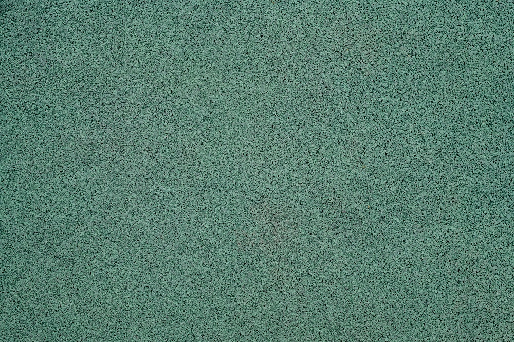 Beautiful green grainy texture background. rubber coating for sports grounds.