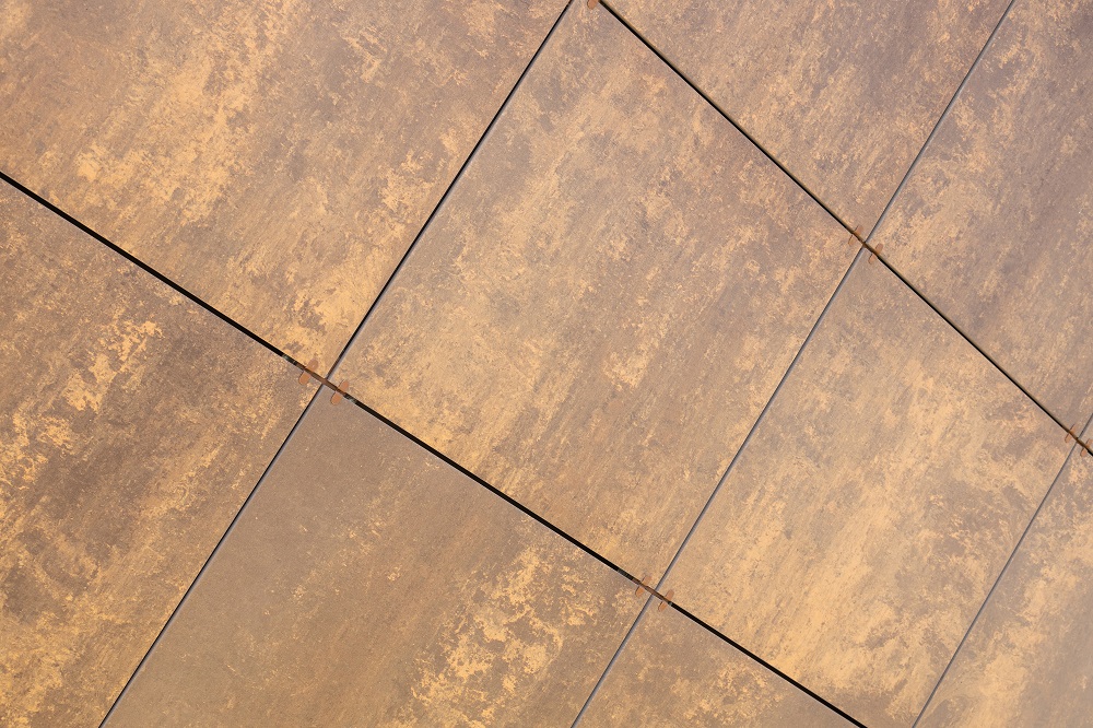Diagonal view at beige-brown uneven coloured tile on wall, for architecture design.